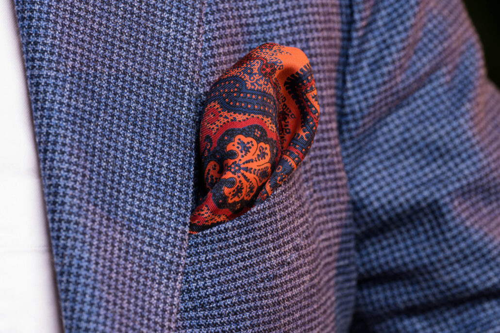 A colorful pocket square in a blue suit jacket 