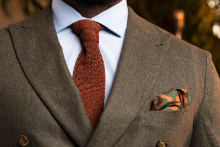 A photo of an Orange Knit Tie worn with a brown suit