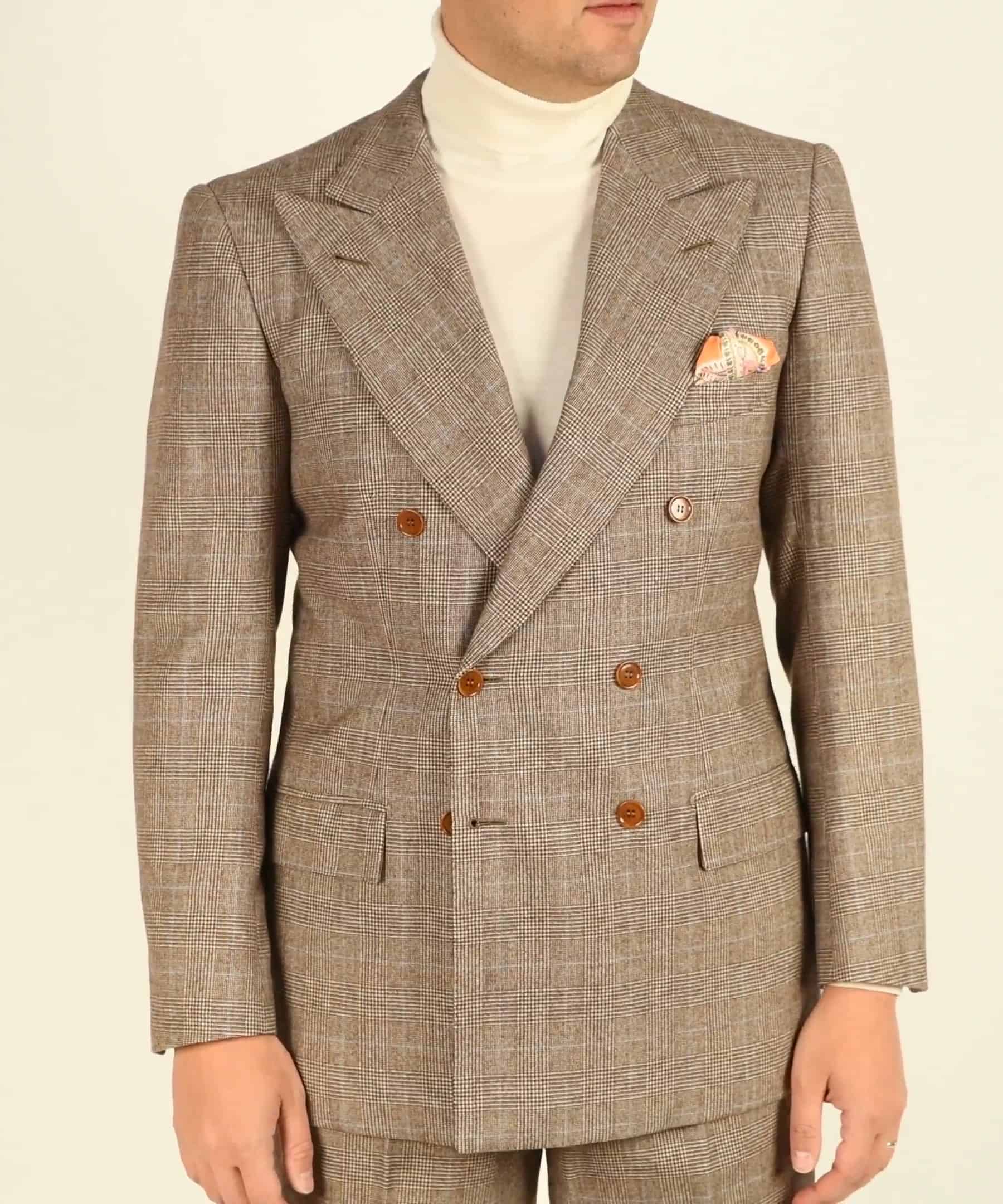An ivory merino wool turtleneck worn under a brown check suit