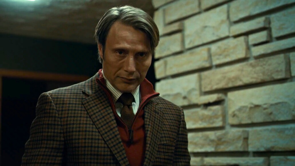 Mads Mikkelsen as Hannibal Lecter wearing a deep red zip neck sweater