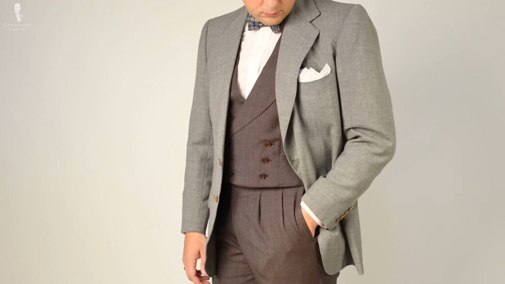 Raphael employs spezzato by combining a gray odd jacket with matching brown waistcoat and trousers
