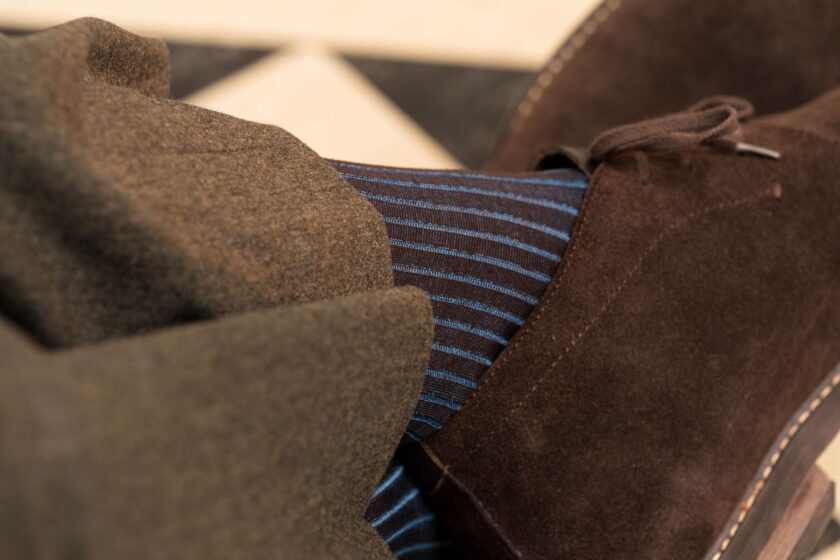 A photo of dark brown and bright blue stripped socks that are ribbed 