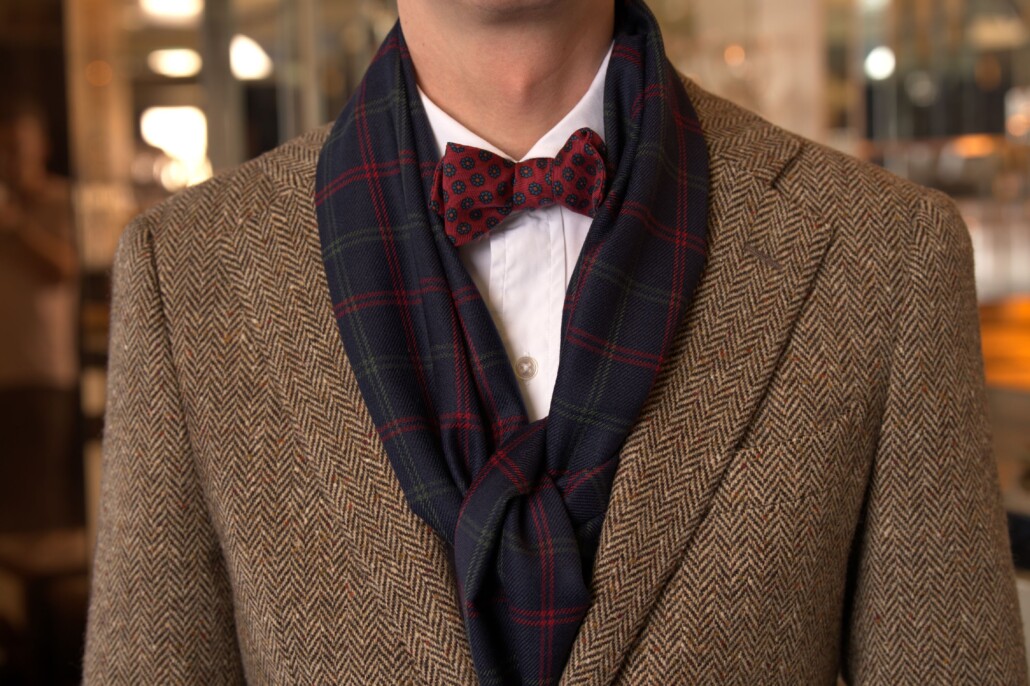 A photo of a man wearing a scarf and bow tie