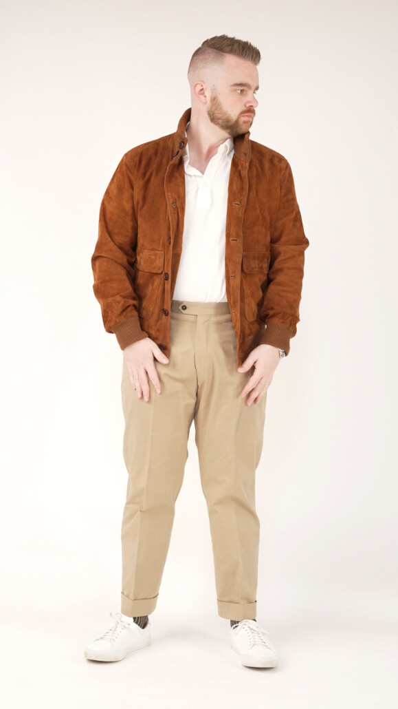 Nathan creates a tonal look by pairing his tan bomber jacket with a pair of classic khakis