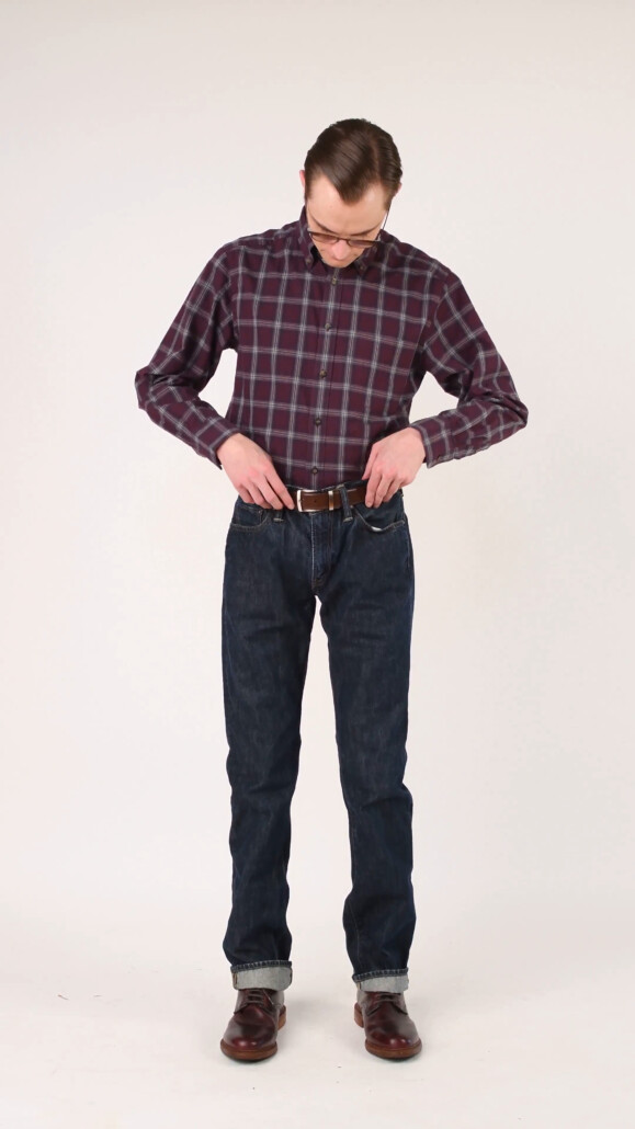 Preston admires his classic blue denim jeans that pair nicely with his checked flannel shirt