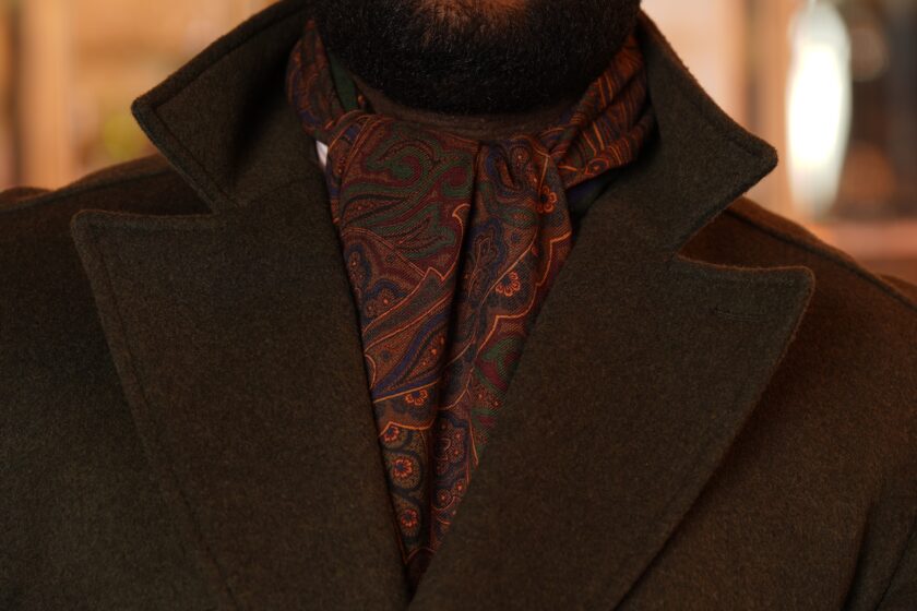 A view of the V of an overcoat with a richly colored scarf 