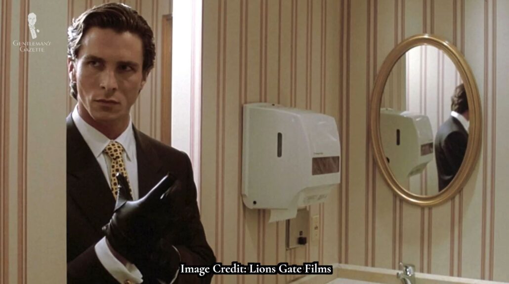 Christian Bale as Patrick Bateman in American Psycho donning gloves [Image Credit: Lionsgate]