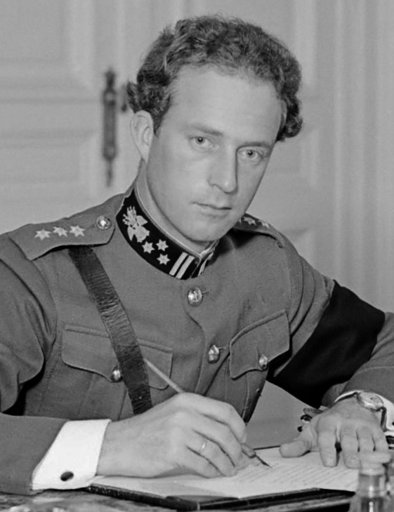 A man in a military uniform wearing an arm band