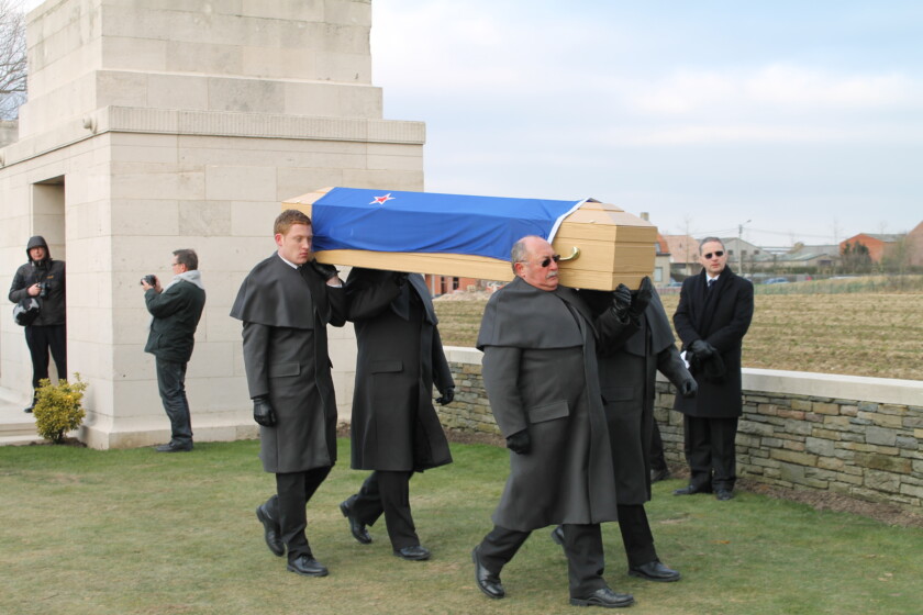 A photo of pallbearers carrying a casket. 