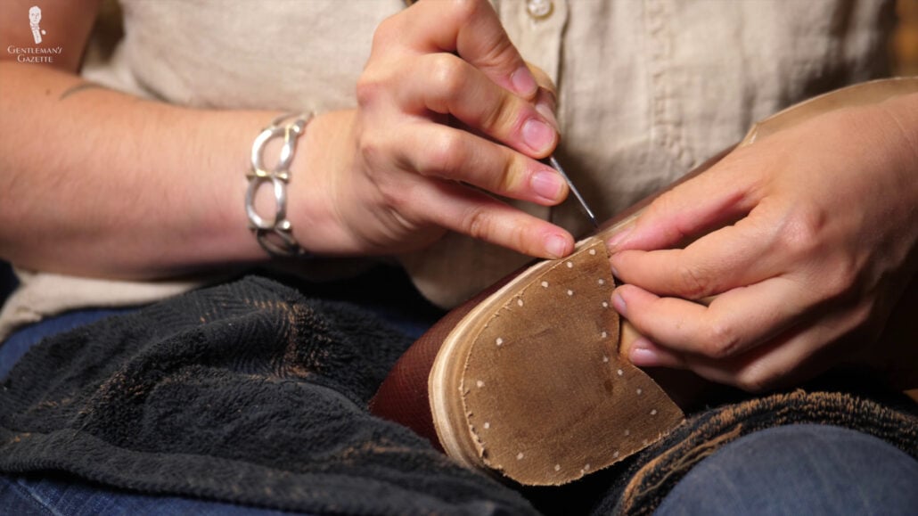 Amara checking the heel of Raphael's bespoke shoe.