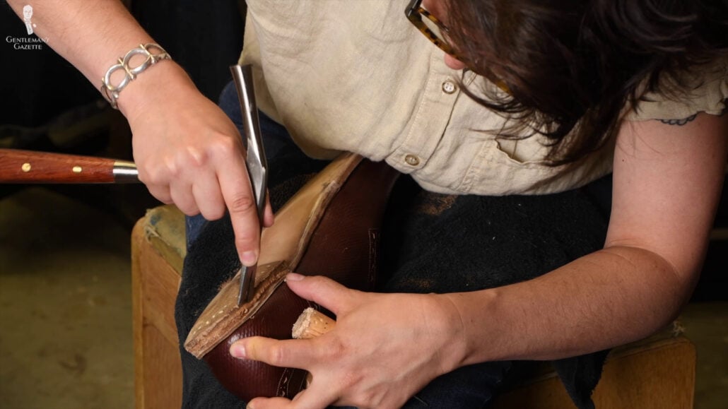 Amara Uses A Pin Hammer To Flatten And Neaten The Edges Of The Heel Layer Amara uses a pin hammer to flatten and neaten the edges of the heel layer.