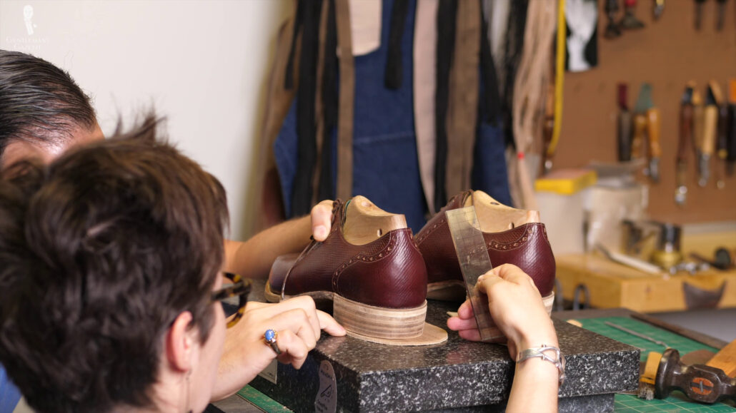 Raphael and Amara working side by side to making changes to his bespoke shoes.