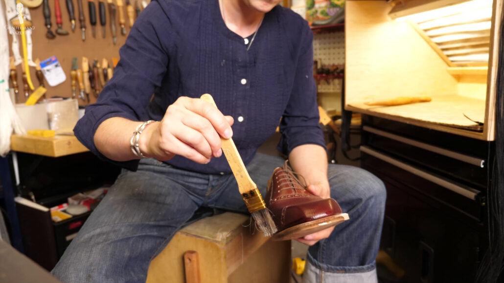 Coating the leather shoes with water for malleability and softness.