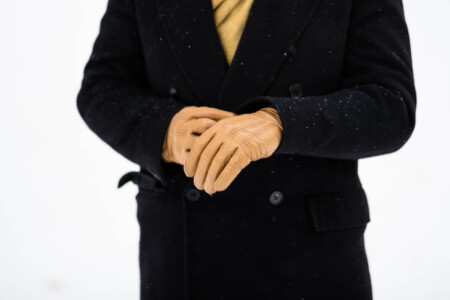 Photo of yellow gloves worn with a dark overcoat