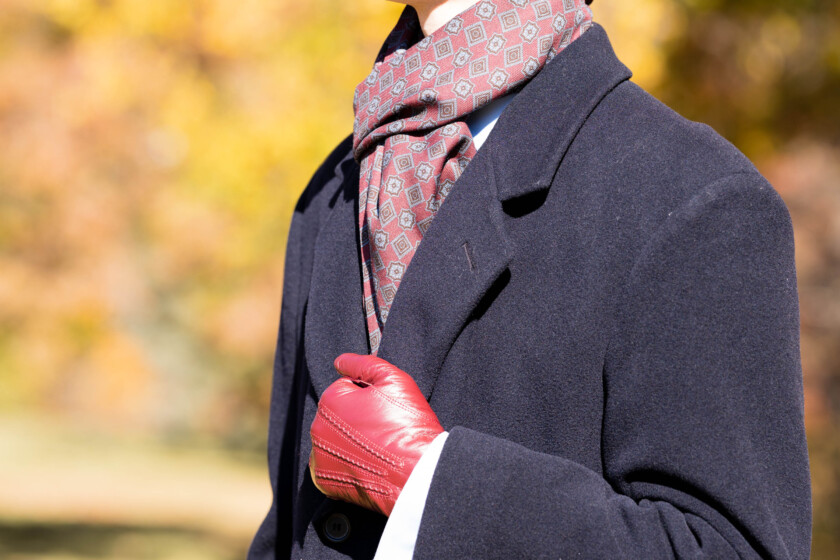 Preston wearing an overcoat with scarf and gloves