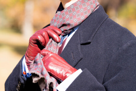 A man knots a scarf around his neck