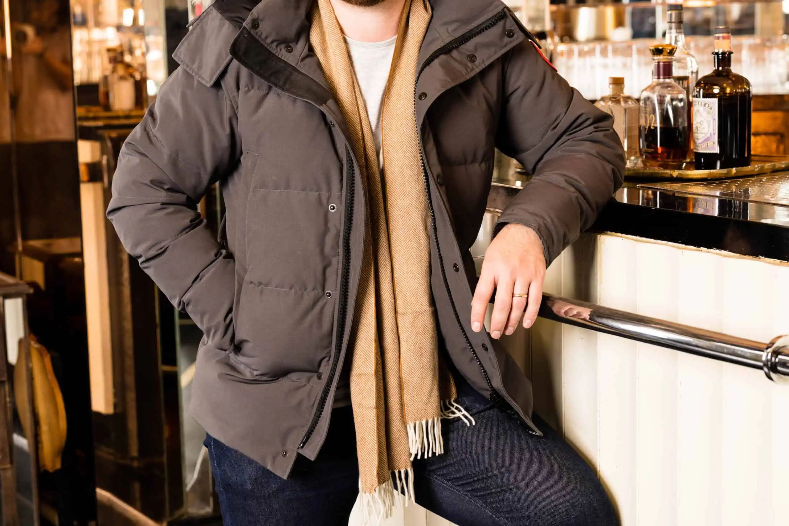 A photo of a man's midsection wearing a scarf and puffer jacket