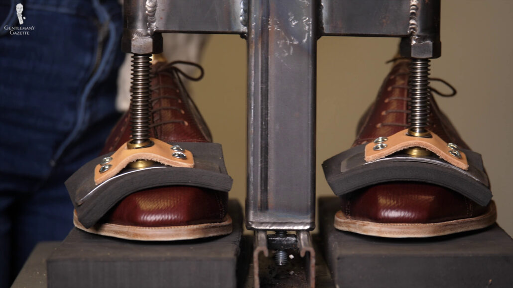 The shoes are pressed down in the vamp area to keep the shoe in place and pressed down to really compact the heel.