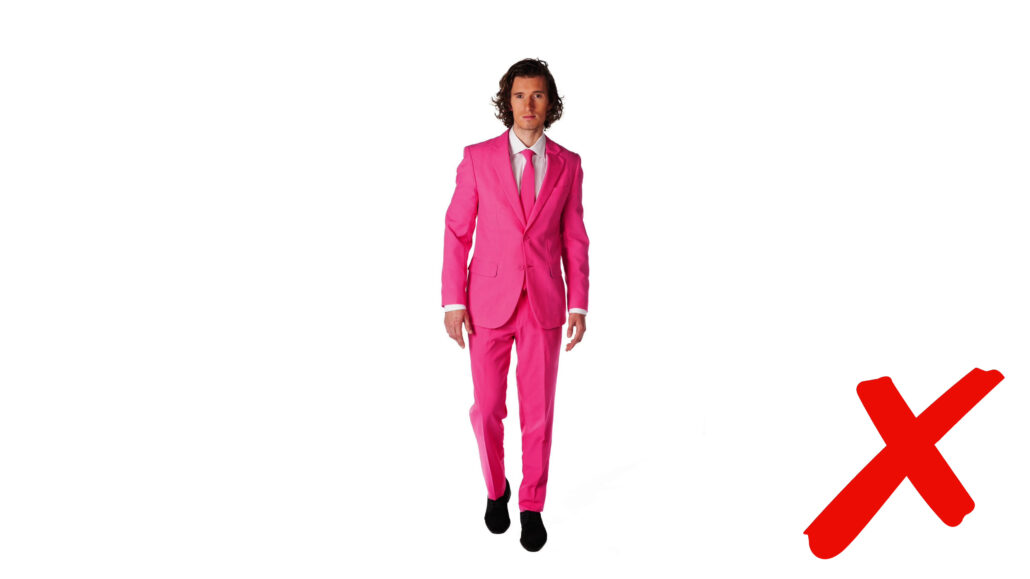 Wedding attendee in a bright pink suit ensemble.