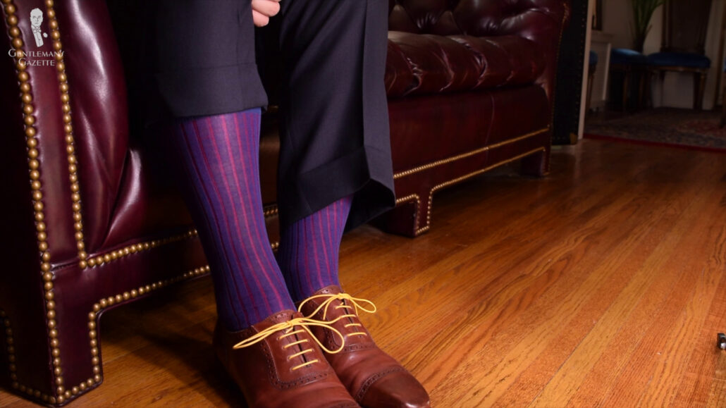 Dark brown leather shoes blend well with blue and red socks.