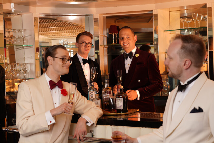 Four men gathered around a bar in Black Tie