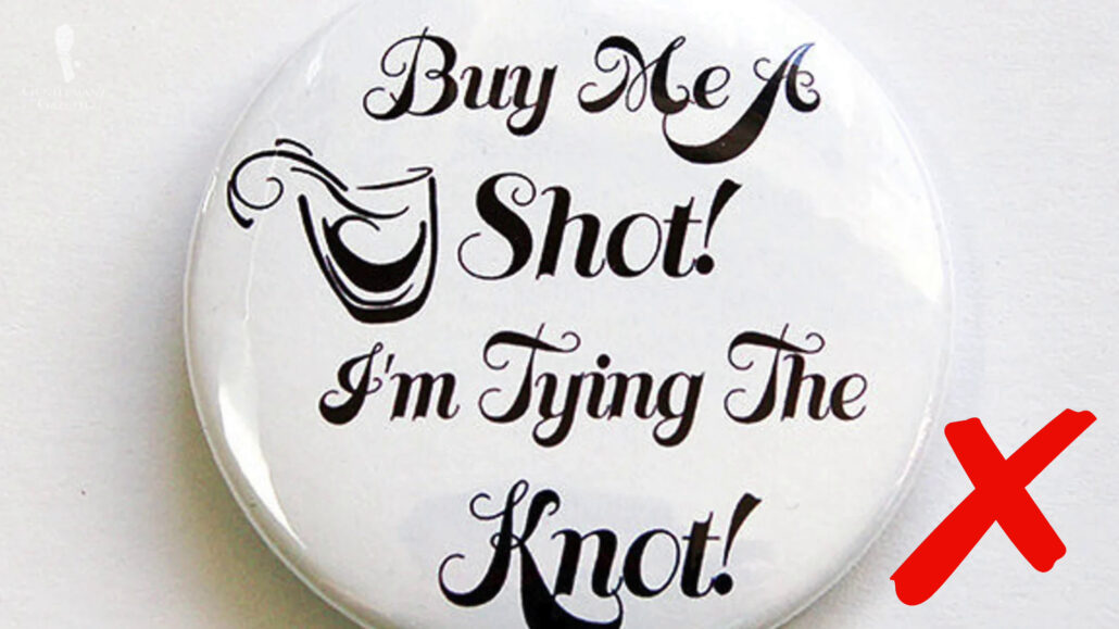 A somewhat vulgar novelty button displaying the phrase, "Buy me a shot! I'm tying the knot!"
