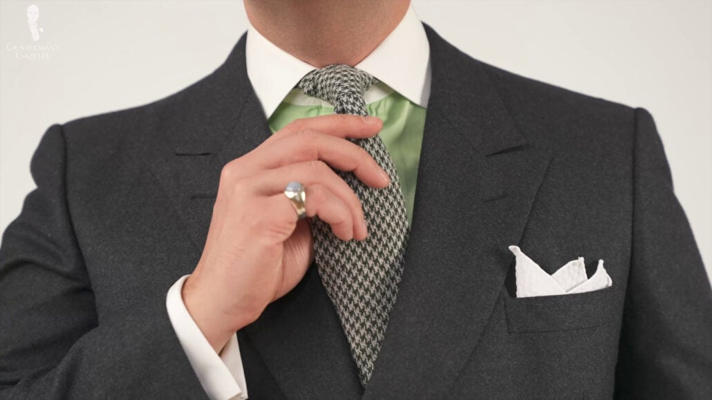 Raphael is in a plain charcoal suit, white and mint green shirt, green checkerboard necktie, and white pocket square. White Linen Pocket Square with Handrolled Edges made in Italy - Fort Belvedere