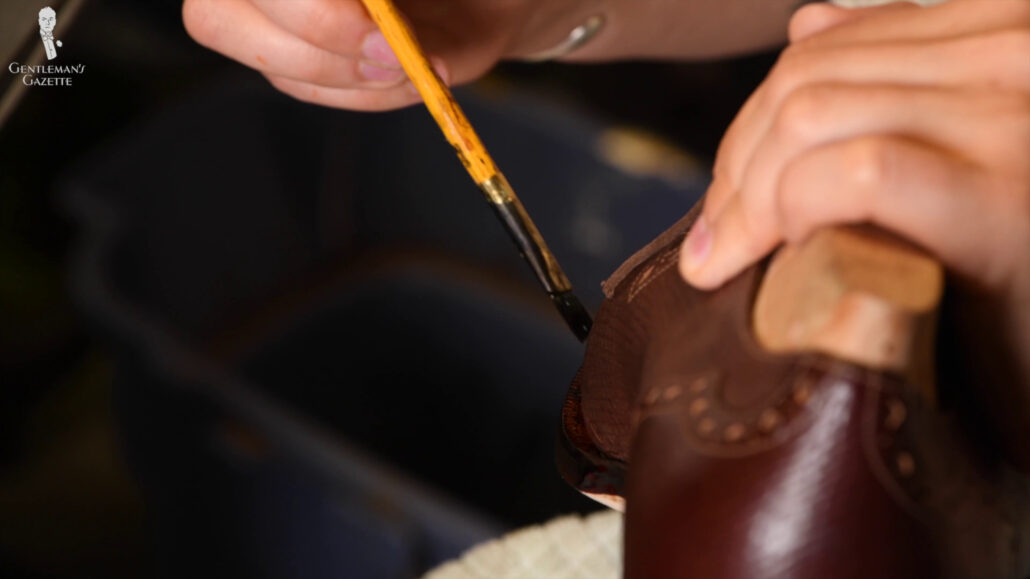A brush is used to carefully and evenly spread the dye while preventing any forms of drips.