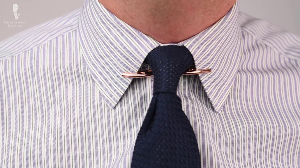 Collar clips should be placed underneath the tie knot.