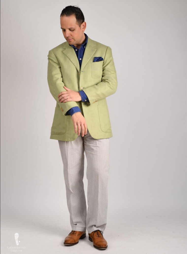 Photo of Raphael wearing a green linen jacket with seersucker trousers