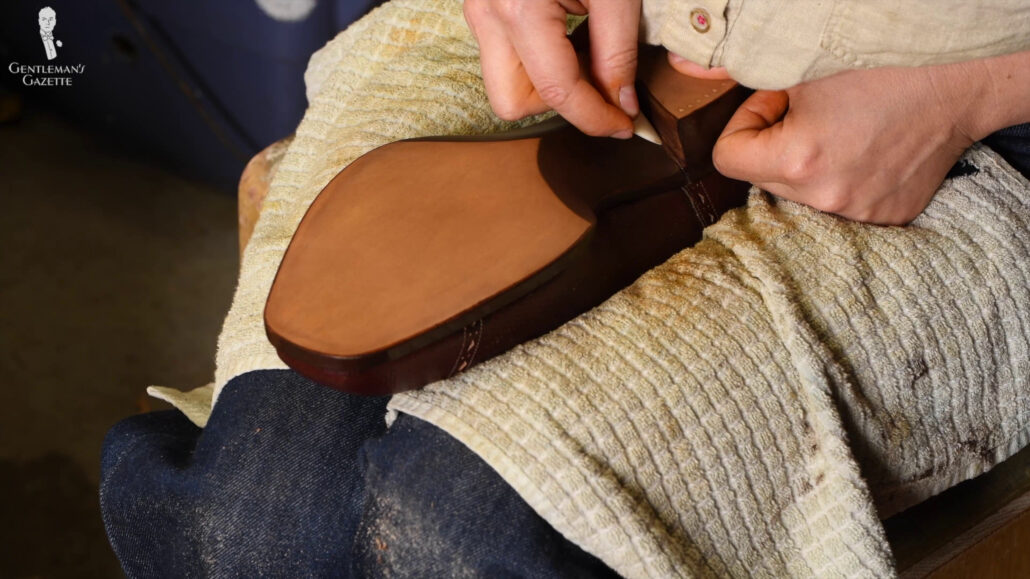The elk bone is once again used to evenly distribute the dye in the leather.