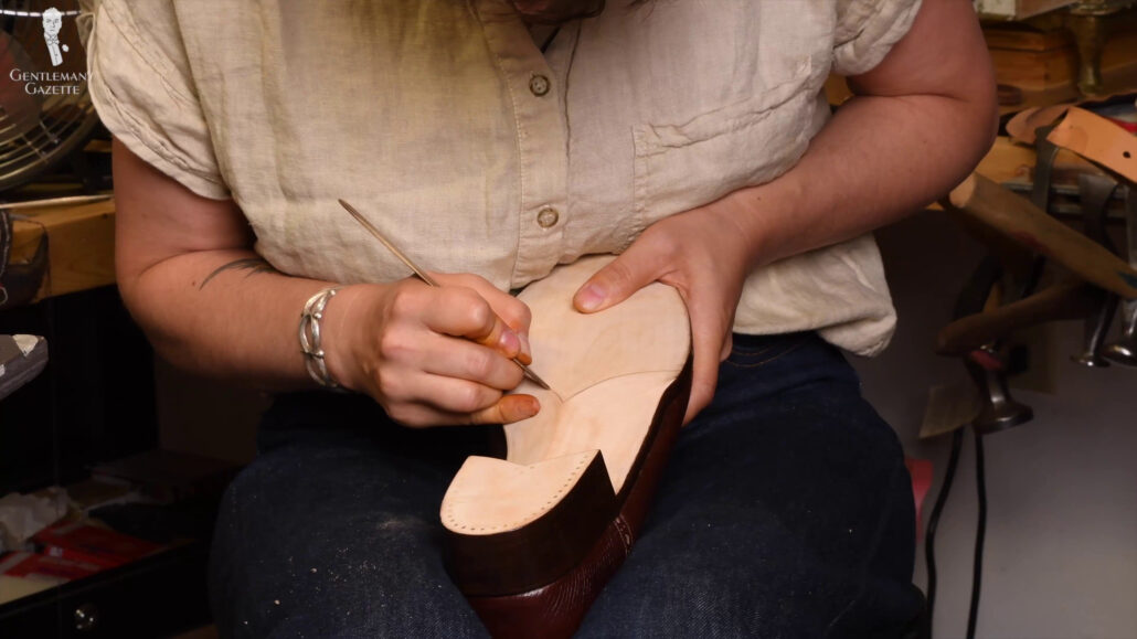 Amara inscribbing distinct dividing lines onto the sole of the shoe.