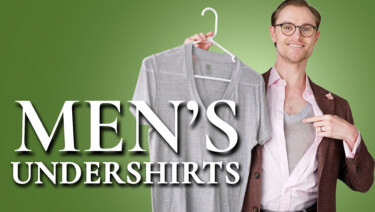 Preston, in a reddish brown sport coat, charcoal gray trousers, and pink dress shirt, holds a gray undershirt on a hanger while pointing to one he is wearing; text reads, "Men's Undershirts"