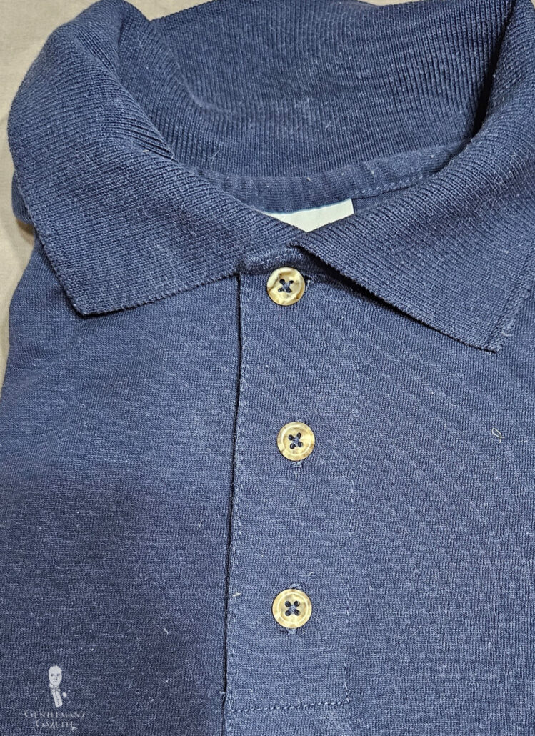 Photo of navy polo shirt with imitation hornbuttons