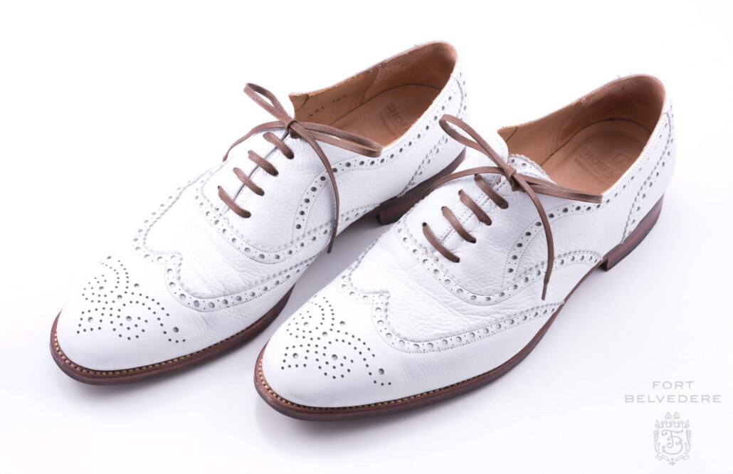 This pair of white bucks is finished in a full brogue style