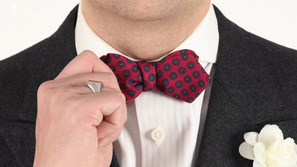 Red dotted bow tie with white boutonniere 