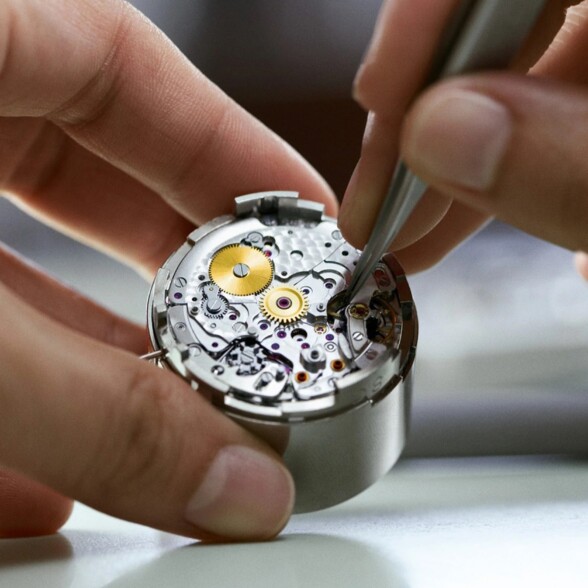 A horologist at work, adjusting various watch parts