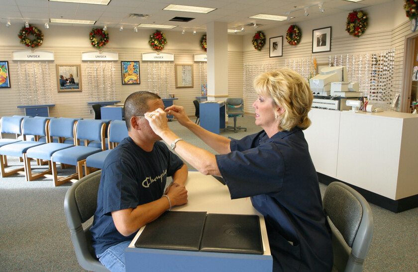 Photo of an optician helping an eye patient