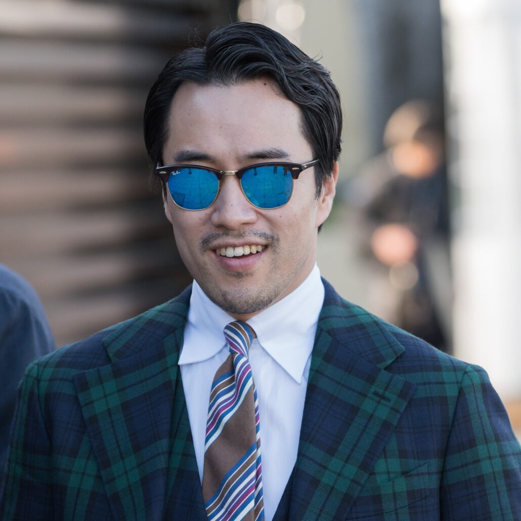 Photo of a man in blue mirror Clubmaster sunglasses with tartan suit 