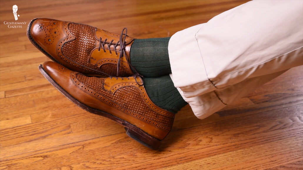 The vibrant color of green socks in khaki trousers.