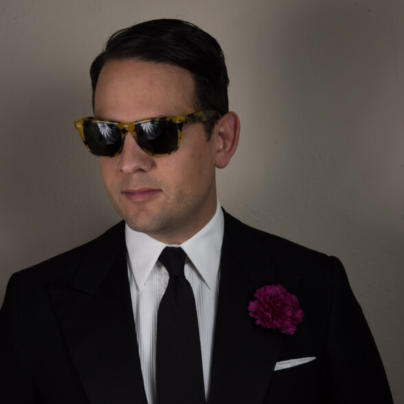 Photo of Raphael wearing overly bold sunglasses with a suit