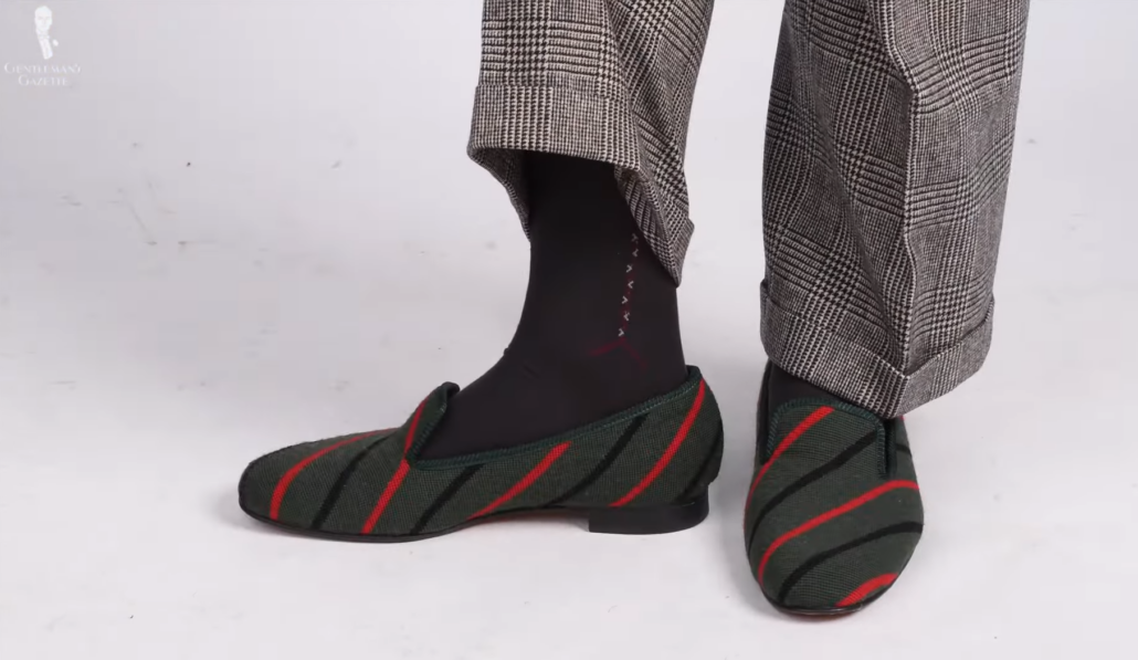 A typical house shoes in green with red stripes.
