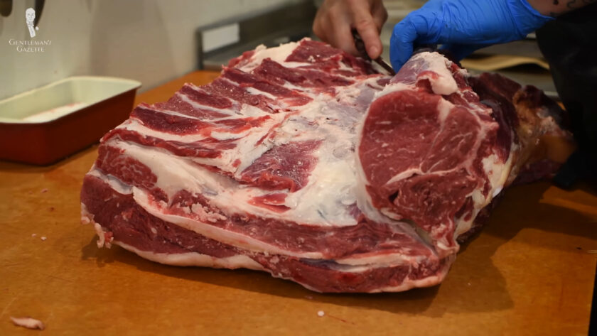 Photo of a Butcher cutting steak perpendicular to the muscle fiber