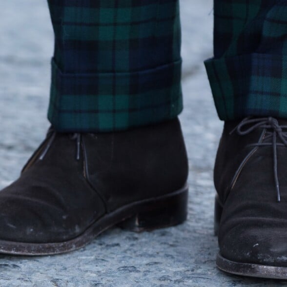 Photo of Dark chukka boots worn with plaid trousers cuffed