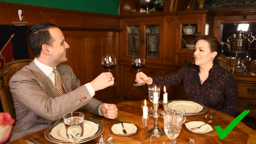 Photo of Raphael and Teresa toast with wine glasses table manners