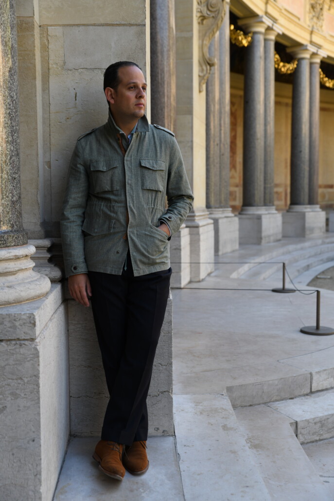 Photo of Raphael in Safari jacket, cuffed navy trousers, brown suede chukka boots