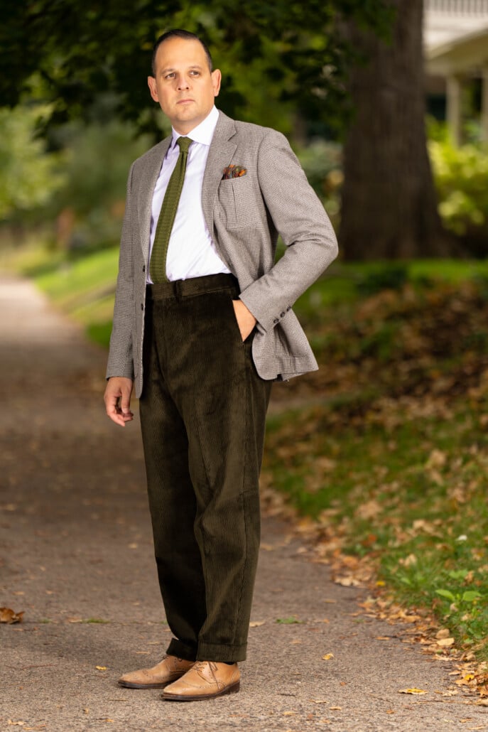 Photo of Raphael wearing Dark Olive corduroy with gray coat and olive silk knit tie