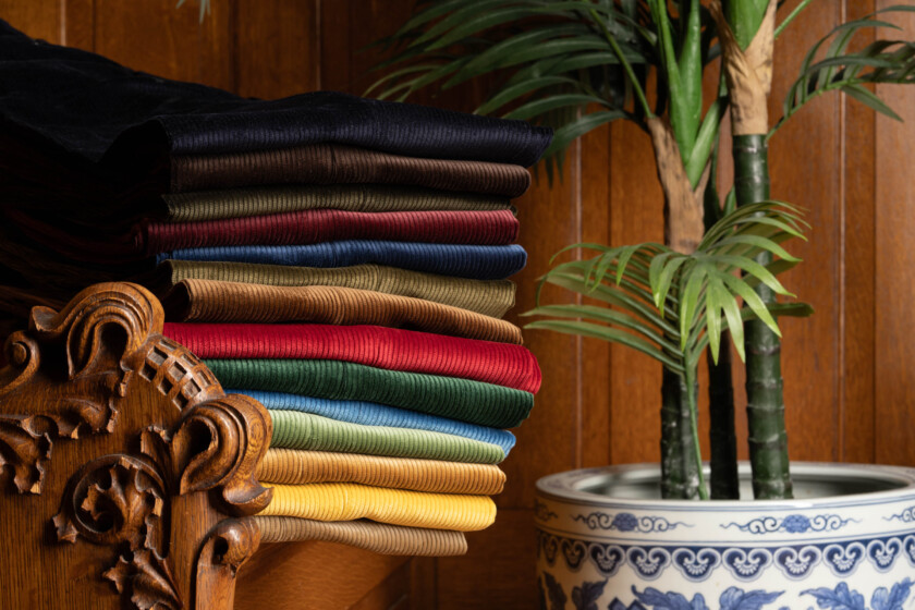 Photo of corduroy stacked near a potted plant
