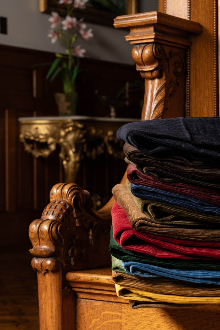 Lifestyle Stack Of Corduroy Trousers Photo of a stack of corduroy on an antique chair