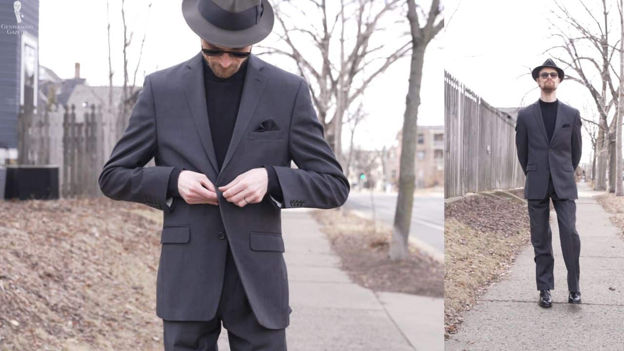 Preston wearing neutral tones of black mock-neck sweater and dark charcoal gray suit for a quiet luxury look